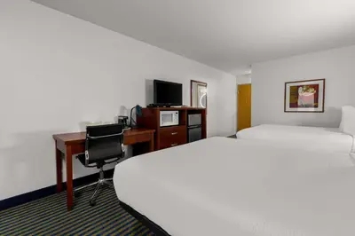 a hotel room with two beds and a desk with a computer at SureStay Plus by Best Western Brooks in Brooks