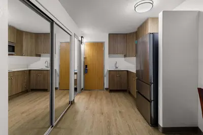 a kitchen with wooden cabinets and a refrigerator at SureStay Plus by Best Western Brooks in Brooks
