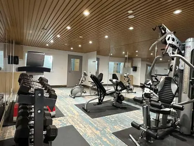 a gym with several exercise bikes and a television at SureStay Plus by Best Western Brooks in Brooks
