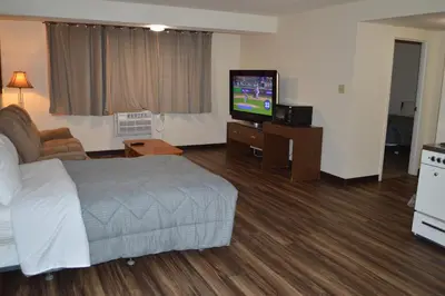 a hotel room with a bed and a flat screen tv at A1 Motel And Campground in Bassano