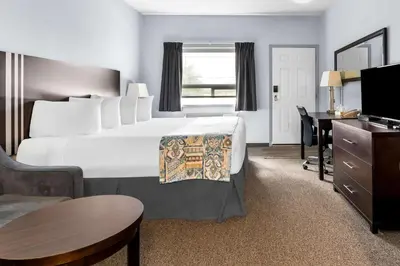 a hotel room with a large bed and a desk at SureStay Studio by Best Western Hardisty in Hardisty