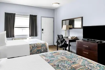a hotel room with two beds and a desk and a television at SureStay Studio by Best Western Hardisty in Hardisty