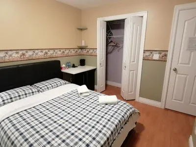 a bedroom with a bed with two towels on it at Three Kittens Guesthouse in Burnaby