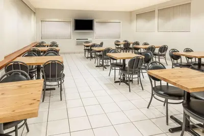an empty classroom with tables and chairs at Super 8 by Wyndham Edmonton/West in Edmonton