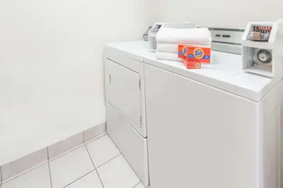 a white laundry room with a washer and dryer at Super 8 by Wyndham Edmonton/West in Edmonton