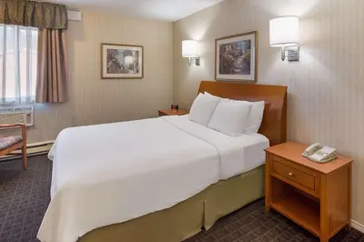 a hotel room with a large white bed and a phone at SureStay by Best Western North Vancouver Capilano in North Vancouver