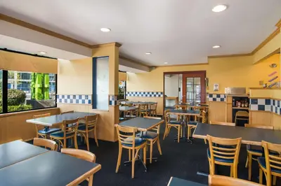 a restaurant with tables and chairs in a cafeteria at SureStay by Best Western North Vancouver Capilano in North Vancouver