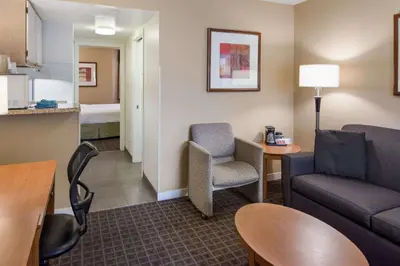 a living room with a couch and chairs in a hotel room at SureStay by Best Western North Vancouver Capilano in North Vancouver
