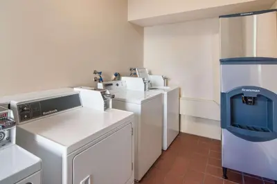 a kitchen with white appliances in a room at SureStay by Best Western North Vancouver Capilano in North Vancouver