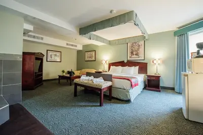 a hotel room with a bed and a table at Harrison Lake Hotel in Harrison Hot Springs