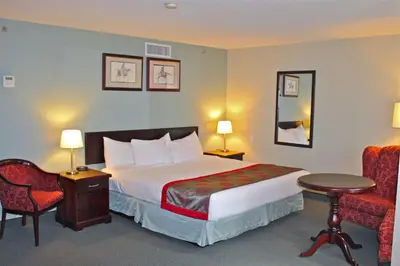 a hotel room with a bed and a chair at Harrison Lake Hotel in Harrison Hot Springs
