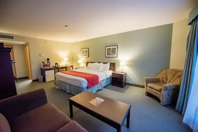 a hotel room with a bed and two chairs at Harrison Lake Hotel in Harrison Hot Springs