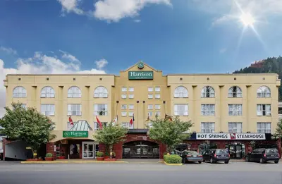 a large building with cars parked in front of it at Harrison Lake Hotel in Harrison Hot Springs