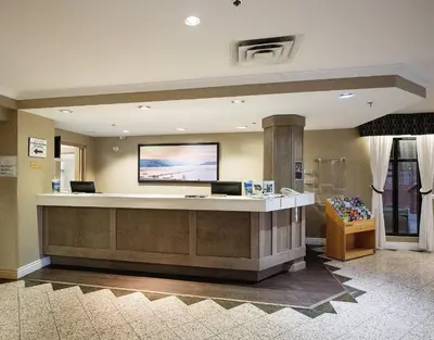 a lobby with a waiting area with a large screen at Harrison Lake Hotel in Harrison Hot Springs