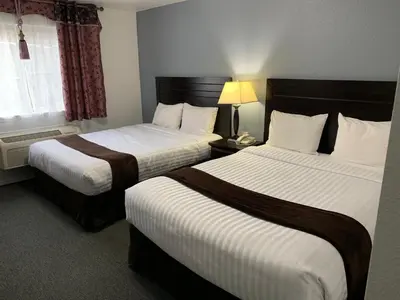 a hotel room with two beds and a lamp at Lake Country Inn in Winfield