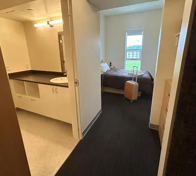 a room with a bed and a bathroom with a sink at UBC Okanagan Campus in Kelowna