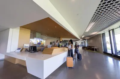 a woman standing in an airport with her luggage at UBC Okanagan Campus in Kelowna