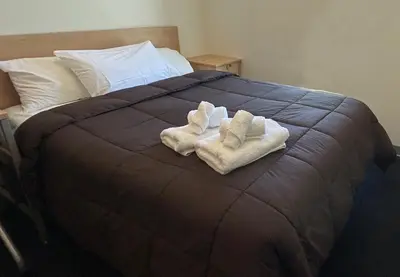 a bed with two towels on top of it at UBC Okanagan Campus in Kelowna