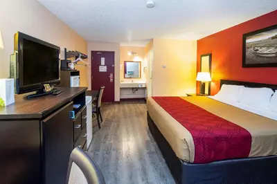a hotel room with a bed and a flat screen tv at Econo Lodge in Edson