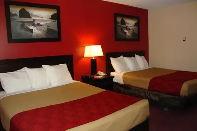 two beds in a hotel room with red walls at Econo Lodge in Edson
