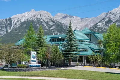 a building with mountains in the background at Pocaterra Inn & Waterslide in Canmore