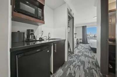 a kitchen with a sink and a microwave in a room at Sandman Hotel Red Deer in Red Deer