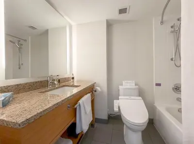 a bathroom with a toilet and a sink and a tub at Coast Chilliwack Hotel by APA in Chilliwack
