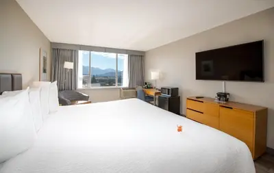 a hotel room with a large bed and a flat screen tv at Coast Chilliwack Hotel by APA in Chilliwack