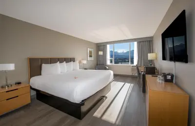 a hotel room with a large bed and a television at Coast Chilliwack Hotel by APA in Chilliwack