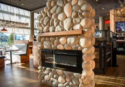 a fireplace made out of logs in a restaurant at Coast Chilliwack Hotel by APA in Chilliwack