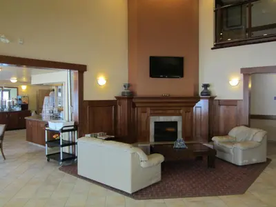 a living room with two chairs and a fireplace at Super 8 by Wyndham Fort Nelson BC in Fort Nelson