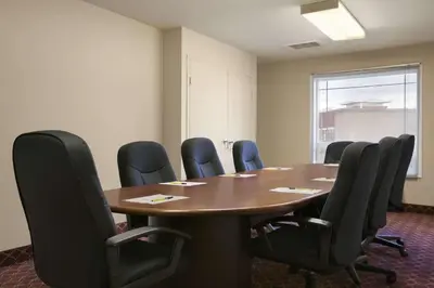 a conference room with a wooden table and chairs at Super 8 by Wyndham Fort Nelson BC in Fort Nelson