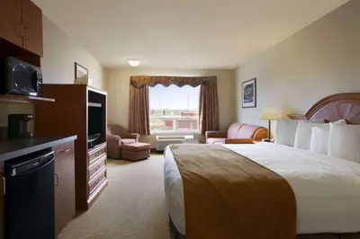 a hotel room with a bed and a television at Super 8 by Wyndham Fort Nelson BC in Fort Nelson