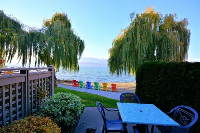 a blue table and chairs next to the ocean at Manteo at Eldorado Resort in Kelowna