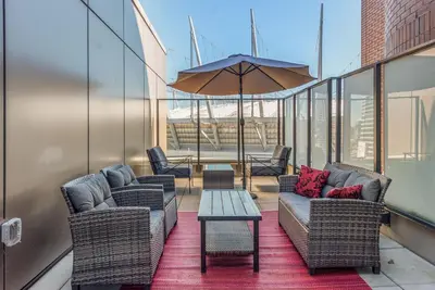 a balcony with chairs and a table and an umbrella at Hotel Willo - previously known YWCA Hotel in Vancouver