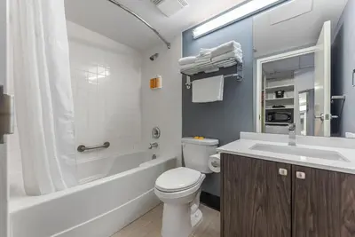 a bathroom with a toilet and a tub and a sink at Hotel Willo - previously known YWCA Hotel in Vancouver