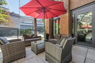 a patio with chairs and a red umbrella at Hotel Willo - previously known YWCA Hotel in Vancouver