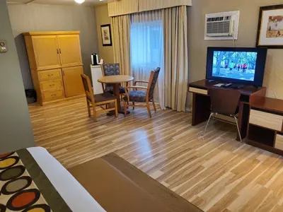 a hotel room with a desk and a television and a room at Super 8 by Wyndham Duncan in Duncan