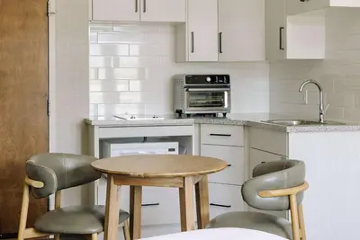 a kitchen with a table and two chairs and a sink at Balcomo, a Ramada by Wyndham in Penticton