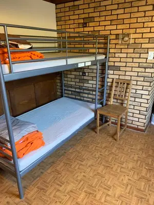a room with two bunk beds and a chair at Vancouver Backpacker House - 10 min walk to Metrotown skytrain station in Burnaby