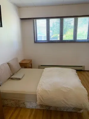 a large bed in a room with two windows at Vancouver Backpacker House - 10 min walk to Metrotown skytrain station in Burnaby