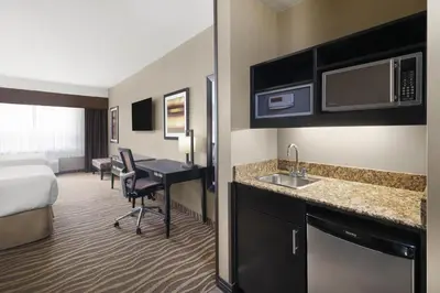 a hotel room with a bed and a desk with a sink at Best Western Premier Freeport Inn Calgary Airport in Calgary