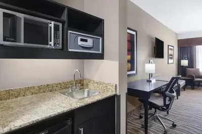 a kitchen with a sink and a desk in a room at Best Western Premier Freeport Inn Calgary Airport in Calgary