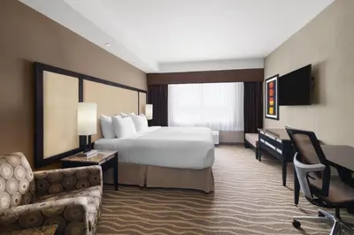 a hotel room with a bed and a desk and chair at Best Western Premier Freeport Inn Calgary Airport in Calgary