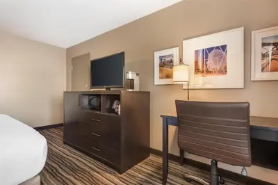 a hotel room with a bed and a desk with a television at Best Western PLUS Calgary Centre Inn in Calgary