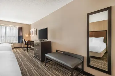 a hotel room with a bed and a mirror at Best Western PLUS Calgary Centre Inn in Calgary