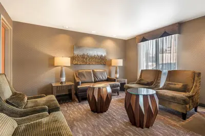 a living room with chairs and a couch and a table at Best Western PLUS Calgary Centre Inn in Calgary