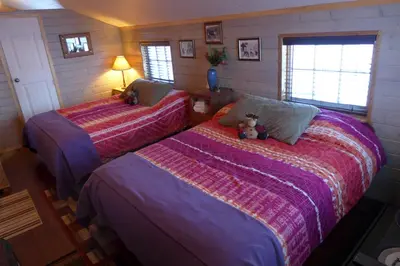 a bedroom with two beds with a teddy bear sitting on them at Mountain Thyme Getaway in Barkerville