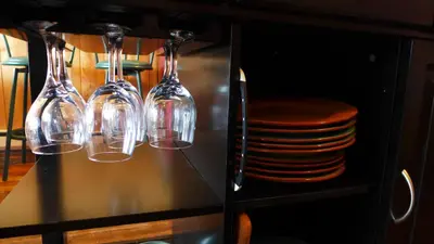 four wine glasses sitting on a table with plates at Mountain Thyme Getaway in Barkerville