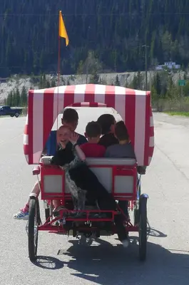 a group of people riding in a red and white pulled wagon at Mountain Thyme Getaway in Barkerville